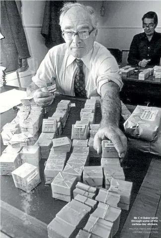  ?? PHOTOS: PRESS ARCHIVES HISTORIC COLLECTION ?? Mr C H Baker sorts through some of the carless-day stickers.