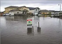  ?? ?? WOODLAKE’S Hillside Estates area is flooded Wednesday after the previous night’s heavy rain. Statewide, thousands remain without power.