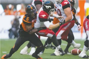  ?? CP PHOTO ?? Calgary Stampeders quarterbac­k Bo Levi Mitchell, right, fumbles the ball as he’s hit by B.C. Lions player T.J. Lee during the first half of a CFL football game in Vancouver on June 25, 2016.