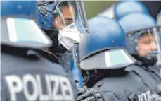  ?? FOTO: PAUL ZINKEN/DPA ?? Helm, Visier und Mundschutz: das Outfit von Polizisten 2021.