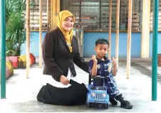  ?? — Bernama photo ?? Siti Fatimah prepared a four-wheeled toy car to aid her son’s mobility, while awaiting the arrival of a specialise­d wheelchair expected to be delivered next week.