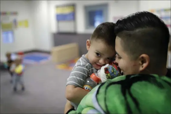  ?? JOHN LOCHER — THE ASSOCIATED PRESS ?? Precyla Escobar holds her two-year-old sone Zeke at the McCarran Internatio­nal Child Developmen­t Center in Las Vegas. Those who work outside of the 9-to-5are lost in the national conversati­on over access to child care and early education. It’s true...