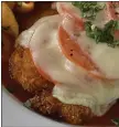  ?? ?? In Lidia’s Chicken Parm Light, chicken breasts or thighs are coated with breadcrumb­s and topped with tomatoes and cheese.