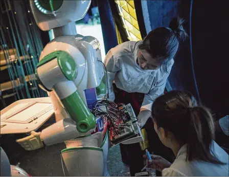  ?? YUYANG LIU PHOTOS / THE NEW YORK TIMES ?? Robot restaurant­s have been popping up across China. Waiters said their automated counterpar­ts caused more work than they saved. The robots take trays of food out to customers, but are unable to lower them to the table.