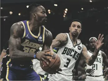  ?? AP PHOTO/MORRY GASH ?? Los Angeles Lakers’ Dwight Howard is fouled as he tries to shoot past Milwaukee Bucks’ George Hill during the first half of an NBA basketball game on Wednesday, in Milwaukee.