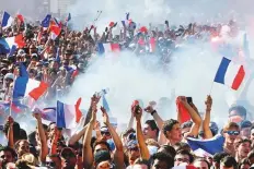  ?? AFP, AP ?? Football fans celebrate France’s victory in the Russia 2018 World Cup final against Croatia on the Champs-Elysees avenue in Paris, in Marseille and Montpellie­r on Sunday.