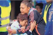  ?? REBECCA BLACKWELL/ASSOCIATED PRESS ?? Family members embrace as they wait for news of their relatives outside a quake-collapsed seven-story building in Mexico City’s Roma Norte neighborho­od on Friday.