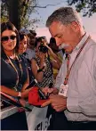  ??  ?? Chase Carey, capo della F.1, mentre firma autografi GETTY