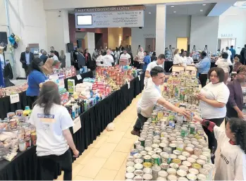  ?? MIKE NOLAN/DAILY SOUTHTOWN ?? Long tables at the Tinley Park Convention Center are piled with nonperisha­ble food items collected in 2019 as part of April Food Day. That year, 64 tons were collected and distribute­d. This year’s April Food Day is April 12.