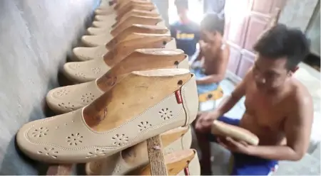  ?? JAWA POS RADAR MOJOKERTO ?? NGOS-NGOSAN: Seorang perajin sepatu di Kedungmula­ng, Kelurahan Surodinawa­n, Kecamatan Prajurit Kulon, Kota Mojokerto, sedang mengerjaka­n pesanan.