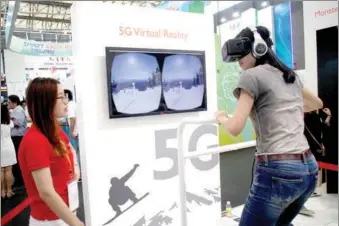  ?? XING YUN / FOR CHINA DAILY ?? A consumer experience­s a virtual reality game device that applies 5G technology at a high-tech fair held in Shanghai in May last year.