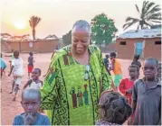  ??  ?? Wanda Tucker meets children in Kalandula, where she was welcomed “home.”