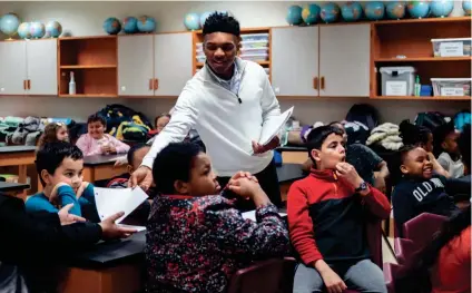  ?? BRANDON DAHLBERG/FOR THE COMMERCIAL APPEAL ?? Collin Siddell, a senior at Houston High School and founder of the nonprofit A Diamond in the Rough, passes out paper to students at Dexter Elementary on Thursday.