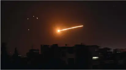  ?? (SANA/Reuters) ?? A STREAK of light is seen in the vicinity of Damascus during what Syrian authoritie­s said was an Israeli air strike, in February.