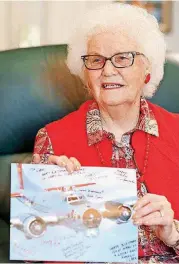  ?? [PHOTO BY DOUG HOKE, THE OKLAHOMAN] ?? Fern Bridges lost her first husband, Allen Chandler Jr., in World War II when his B-17 went down over Germany. Bridges holds a B-17 card signed by the crew of a B-17 that she was able to fly on.