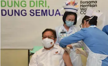  ??  ?? Monica injects Abang Johari with the Covid-19 vaccine.
