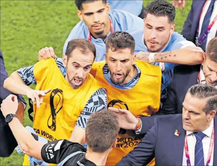 ?? ?? José María Giménez golpea con el codo a un oficial de FIFA mientras Godín y Bentancur increpan al árbitro.