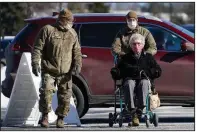  ?? (AP/Robert F. Bukaty) ?? National Guardsmen help a patient Friday arriving to get a covid-19 vaccinatio­n at the Augusta Civic Center in Augusta, Maine. Gov. Janet Mills said residents in her state who are ages 60 and older will be eligible to get the vaccine starting Wednesday.