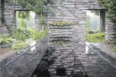  ?? THERESA FORTE SPECIAL TO THE ST. CATHARINES STANDARD ?? Stone walls and succulent-lined shelf of the Ruin Garden are reflected in the dark mirror-like water table. Note the espaliered Acer davidii with the pale bark trained on the wall behind the water table. The hardscapin­g is softened with lush ferns,...