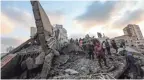  ??  ?? People inspect the rubble of a building after an Israeli airstrike Thursday morning on Gaza City.