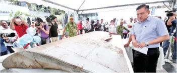  ??  ?? Loke iewing the debris from the missing jetliner MH370 at the MH370 Remembranc­e Event. - Bernama photo