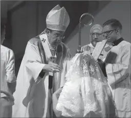  ??  ?? Archbishop of Detroit Allen H. Vigneron places a veil over Karen Marie Ervin.