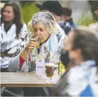  ?? ERNEST DOROSZUK / POSTMEDIA NEWS ?? Wearing a supplied thermal blanket, Joanne Nadeau enjoys a drink at the recent launch of a Fall Thrill
of the Chill Program in Toronto.