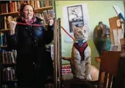  ??  ?? Connie Lipton keeps her cat, Max, on a leash as he roams the bookstore.