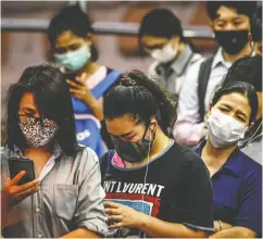  ?? MLADEN ANTONOV / AFP / GETTY IMAGES ?? Commuters wearing protective face masks amid fears of the spread of the coronaviru­s wait to board a boat on in Bangkok, Thailand.