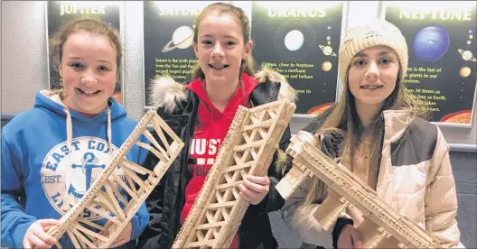 ?? JUANITA MERCER/THE TELEGRAM ?? Selena Ryan, Grace Hemeon, and Olivia Taylor show off the bridges they built using only popsicle sticks and white glue.