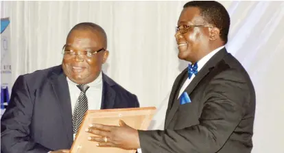  ??  ?? Zimbabwe Institute of Management president Dr Lucky Mlilo (right) hands over a certificat­e to DSK Electrical Wholesaler­s managing director Mr Worthwhile Mugabe for being the Private Sector Leader of the Year during the Zimbabwe Institute of Management...