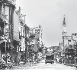  ??  ?? CITY OF RUINS – A military truck navigates through the ruins of Banggolo district in Marawi City. (Keith Bacongco)