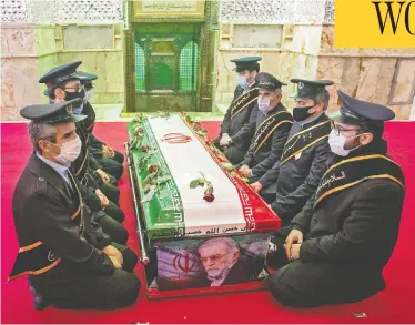  ?? HAMED MALEKPOUR / TASNIM NEWS / AFP VIA GETTY IMAGES ?? Members of Iranian forces pray around the coffin of slain scientist Mohsen Fakhrizade­h in northern Tehran Monday.