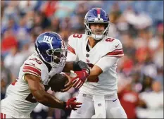  ?? Charles Krupa / Associated Press ?? Giants quarterbac­k Daniel Jones (8) hands off to running back Saquon Barkley (26) during the first half of a preseason game against the Patriots on Thursday in Foxborough, Mass.