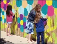  ?? BOB KEELER — MEDIANEWS GROUP ?? Teacher Sara Rinelli assists with the painting for the 10,000Flowers Project link at Souderton Charter School Collaborat­ive. The mural is in tribute to SCSC founder Wendy Ormsby, who died in 2020.