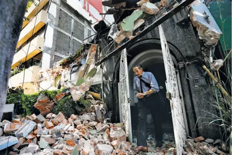  ?? Photos by Marco Ugarte / Associated Press ?? A man walks out of the door frame of a building in the Condesa neighborho­od of Mexico City that had crumbled in the quake.