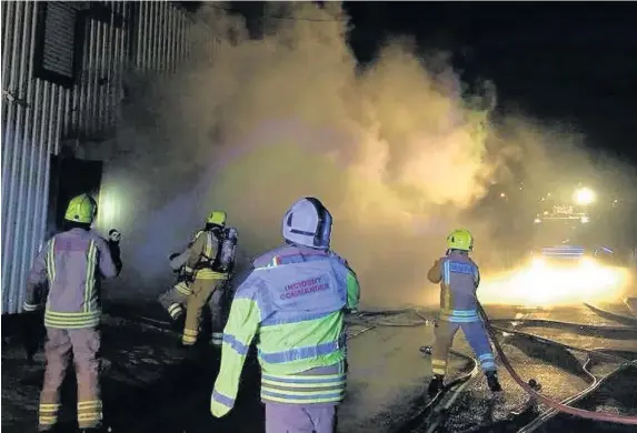  ??  ?? > Vehicles and equipment were damaged by a fire at Central Beacons Mountain Rescue Team in Dowlais, Merthyr Tydfil. Firefighte­rs are pictured at the scene of the blaze