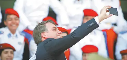  ??  ?? Bastante descontraí­do, o presidente Jair Bolsonaro faz uma selfie no Quartel-General do Exército, em Brasília: dia de muitos protestos