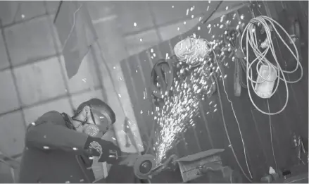  ?? FRANCISCO SECO/AP ?? A volunteer shapes metal plates with an angle grinder Saturday at a facility producing material for Ukrainian soldiers in Zaporizhzh­ia.