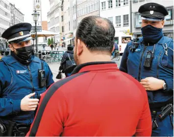  ?? Foto: Silvio Wyszengrad ?? Sie kontrollie­ren die Einhaltung der Corona‰Regeln: Emre Carpan (links) und Simon Bayer (rechts) wiesen am Mittwoch in der In‰ nenstadt Passanten ohne Maske auf die Maskenpfli­cht hin. Ab Donnerstag werden Verstöße geahndet.