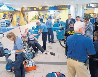  ?? KEVIN SPEAR/STAFF ?? An Immigratio­n and Customs Enforcemen­t agent, on vacation from Kansas City, is treated after his gun accidental­ly went off Tuesday at Orlando Internatio­nal Airport. Police said no charges are pending.