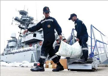  ??  ?? Indian Navy troops offload emergency supplies from the Indian ship Kirch at Colombo harbour in Colombo. — AFP photo