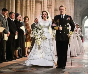  ??  ?? King George VI (Harris) walking his daughter Elizabeth Windsor (Foy) down the aisle in Episode One.