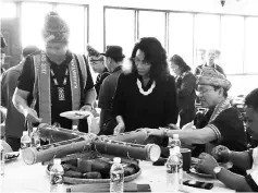  ??  ?? Madius (right) with his wife Dr Jaina and Joniston trying out the traditiona­l food at the Mukim Nabalu Kaamatan.