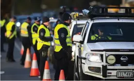  ??  ?? NSW police officers check Victorian drivers for their entry permits as they pass through a border checkpoint in Albury on Wednesday. The closure of the NSW-Victoria border has led to the deployment 650 police and 100 members of the army. Photograph: Lukas Coch/EPA