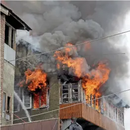  ?? — PTI ?? Fire personnel try to douse a fire that broke out in a residentia­l building at Safakadal Chowk in Srinagar on Friday.