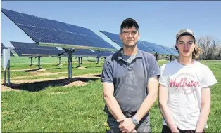  ?? IAN FAIRCLOUGH/THE CHRONICLE HERALD ?? Greg Gerrits and his son James stand in front of solar panels on the family farm near Canning, N.S. The 100-kilowatt system is the largest private system in the Maritimes.