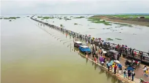  ?? — China Daily/ANN ?? Water woes: People gathering at a road in Yongxiu county, Jiangxi province, which part of it is flooded after the water level of Poyang Lake rose rapidly due to recent continuous downpours.