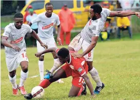  ?? IAN ALLEN ?? Javani Campbell (second right) from Boys’ Town comes under pressure from UWI’s Fabian McCarthy (right), Kemar Flemmings (left), and Rochane Smith during a Red Stripe Premier League at the Barbican field in St Andrew yesterday. UWI won 2-1.