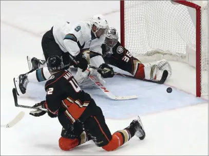  ?? Reed Saxon ?? The Associated Press Sharks left wing Evander Kane scores past Ducks goalie John Gibson in front of defenseman Josh Manson in Game 1 of their first-round playoff series Thursday in Anaheim, Calif. San Jose leads the series 2-0.